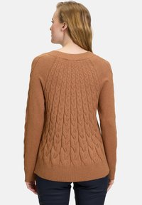 Brauner gestrickter Pullover mit einem strukturierten Kabeldesign auf der Rückseite, geripptem Saum und Rundhalsausschnitt. Glattes Material mit einem gemütlichen Aussehen.
