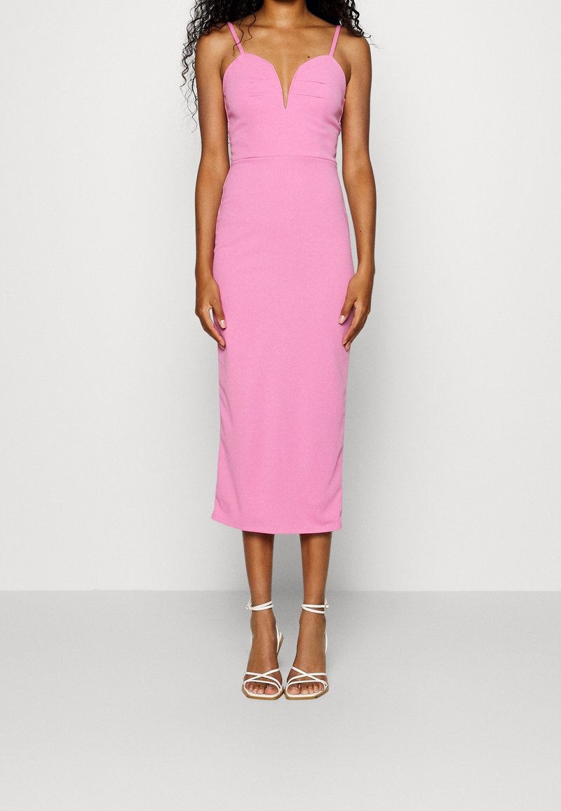 Bloemige roze midi-jurk met een aansluitend lijfje, V-hals en dunne bandjes. Gladde stof met een lichte glans, gedragen met witte sandaaltjes met bandjes.