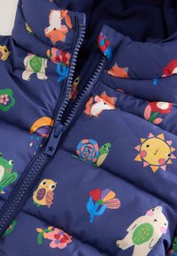 Granatowa ocieplana kamizelka z kolorowymi wzorami zwierząt i kwiatów. Posiada zamek błyskawiczny oraz miękką podszewkę zapewniającą ciepło.