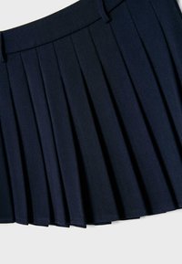 Jupe plissée bleu marine avec passants pour ceinture et taille ajustée, présentée à plat sur un fond blanc.