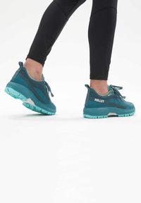 Türkise Wanderschuhe mit einer strukturierten Oberseite, Gummisohlen und Schnürdetails. Sie verfügen über ein Logo an der Seite und eine gepolsterte Ferse für zusätzlichen Halt.