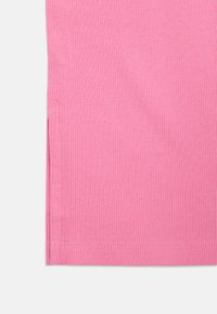 Ribbet rosa stoff med en glatt tekstur. Har en rett kant og sidelommer for enklere bevegelse. Minimale sømdetaljer.