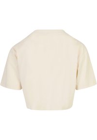 Maglietta corta a maniche corte beige, mostrata dal retro, con scollo rotondo e cuciture semplici lungo i bordi.