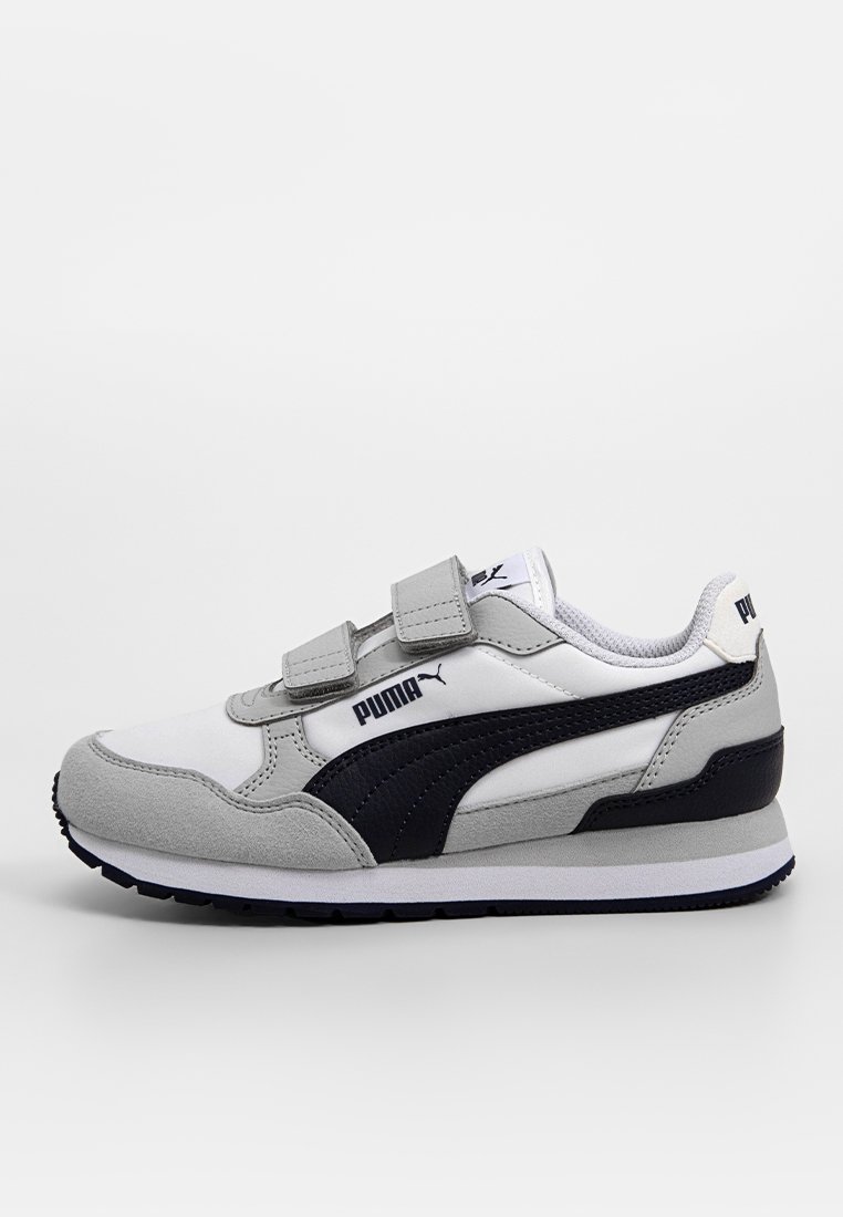 Vit och grå Puma-sneaker med svart rand, två kardborreband och dämpad sula, visad från sidan på en enfärgad bakgrund.
