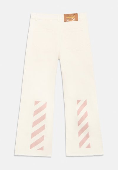 Εκρού τζιν παντελόνια με φαρδιές παντελόνες, τσέπες στο πίσω μέρος, δερμάτινη ετικέτα "DENIM" στη μέση, και ροζ διαγώνιες ρίγες κοντά στα τελειώματα των ποδιών.