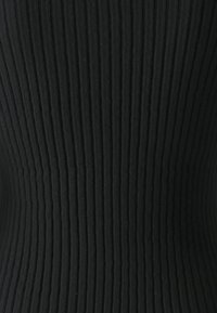 Schwarzer, gerippter Stoff mit vertikalen Streifen, strukturierte Oberfläche und figurbetonte Silhouette. Weiches Material, das Elastizität und Form betont.
