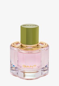 Pink glass perfume bottle with a round, green cap. Gold accents surround the neck, featuring "GANT" in gold text on the base.
