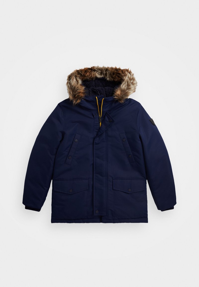 Marinblå parka-jacka med en fuskpälsfoder i huvan, dragkedja och tryckknappar, två framfickor och en mjuk texturerad insida.