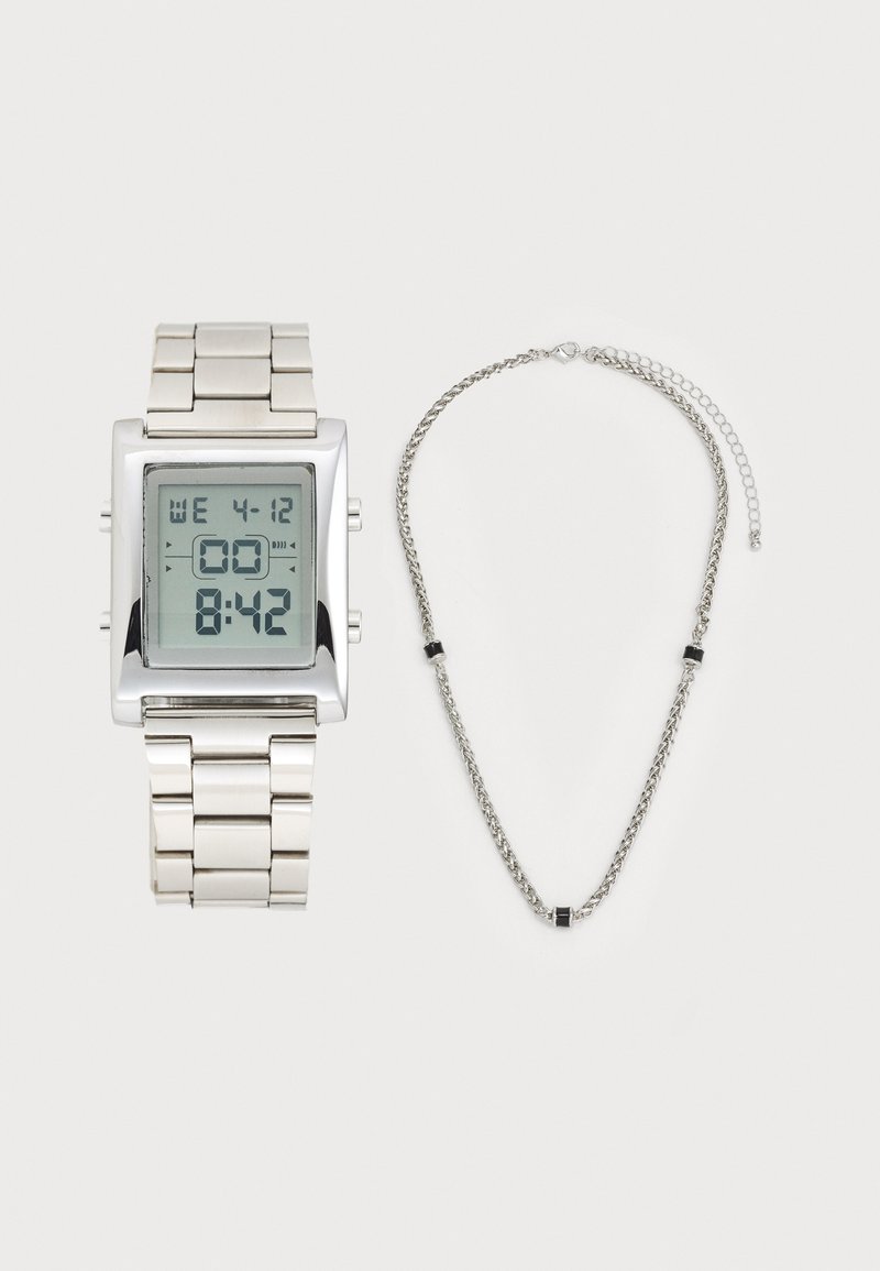 Montre en argent numérique avec un cadran carré et un bracelet en métal, accompagnée d'un collier en chaîne argenté assorti avec des accents de perles noires.