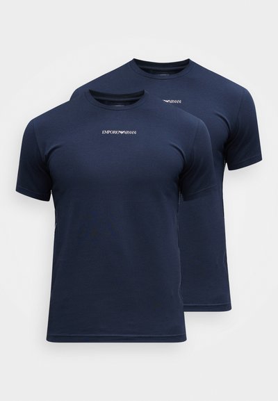 Divi divi tumši zili Emporio Armani iegraujamie T-krekli ar īsām piedurknēm, ar priekšējo logo tekstu, attēloti blakus uz baltas fona.