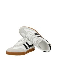 Paire de baskets blanches avec des accents en cuir suédé gris, des bandes noires sur les côtés, des lacets blancs et des semelles en gomme sur fond blanc.
