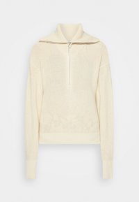 Pull en maille couleur crème à manches longues et col demi-zip à l'avant, présentant un motif côtelé texturé et de larges poignets.