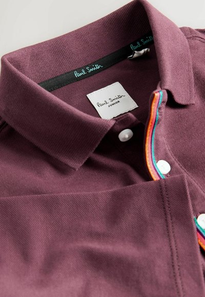 Polo shirt bordeaux con tessuto texturizzato, tre bottoni e un accento a righe multicolori lungo la patta. Presenta un'etichetta del marchio.