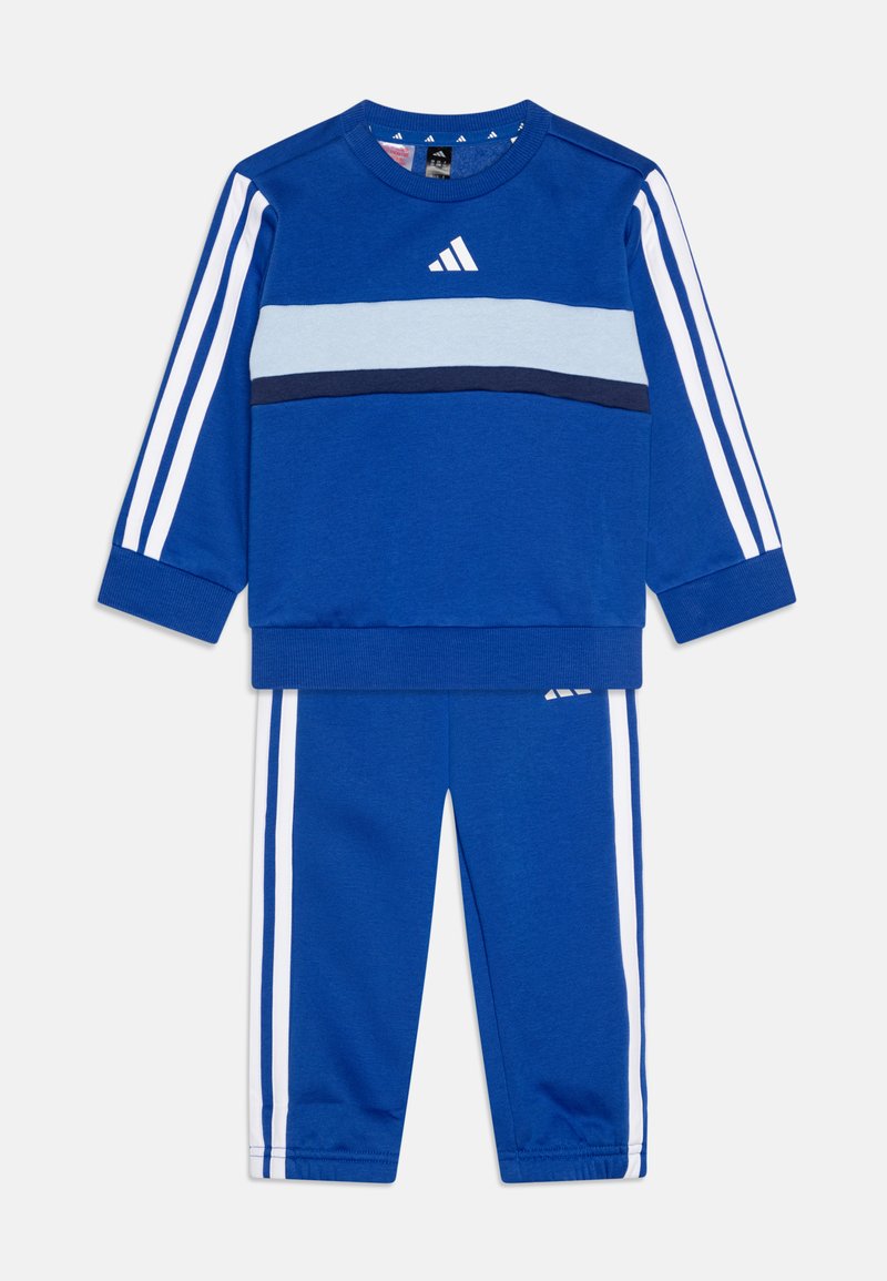 Conjunto de chándal azul que incluye una camiseta de manga larga con rayas horizontales en azul claro y marino, y rayas blancas en los pantalones. Material de algodón suave.