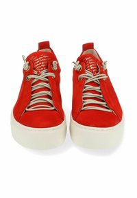 Baskets en suede rouge avec bout rond, lacets couleur crème et semelle texturée blanche. La doublure intérieure présente un texte blanc sur fond rouge.