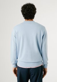 Lichtblauw pullover sweatshirt met een ronde hals, ribgebreide manchetten en tailleband. Glad textuur, eenvoudig ontwerp, zonder patronen of versieringen.