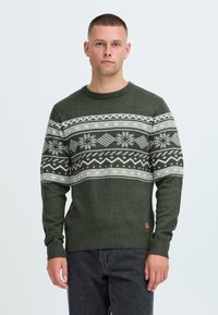 Pulover verde tricotat cu guler rotund, având un model geometric alb și cu fulgi de zăpadă pe piept și manșete și tiv cu nervuri.