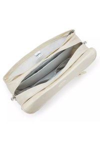 Helle beige rechteckige Tasche mit glatter Textur, Reißverschlussverschluss und mehreren Innenfächern, versehen mit dem Markenetikett.