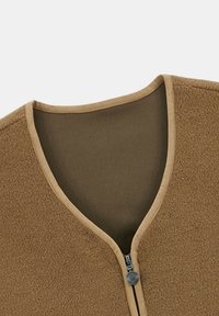 Gilet en polaire de couleur beige avec un col en V, doté d'une fermeture à glissière et d'une doublure intérieure douce, bordé d'un passepoil contrastant.