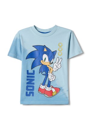 Maglietta azzurro chiaro con Sonic the Hedgehog che mostra il gesto di pace, tre anelli d'oro e la scritta "SONIC" sul davanti.