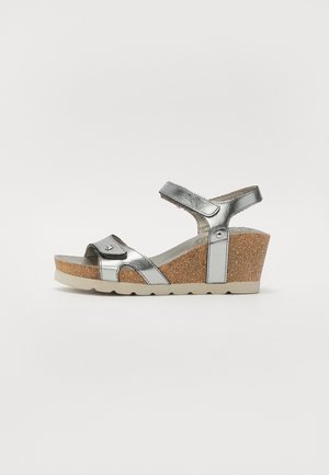 Metallic silver wedge sandal with cork midsole, adjustable ankle strap, and open toe design. Features smooth texture and minimal detailing.