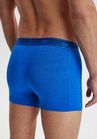 Blå bomulds boxer shorts med en sort mærkevare elastik. Stoffet ser glat ud, og designet er tætsiddende med lige ben.