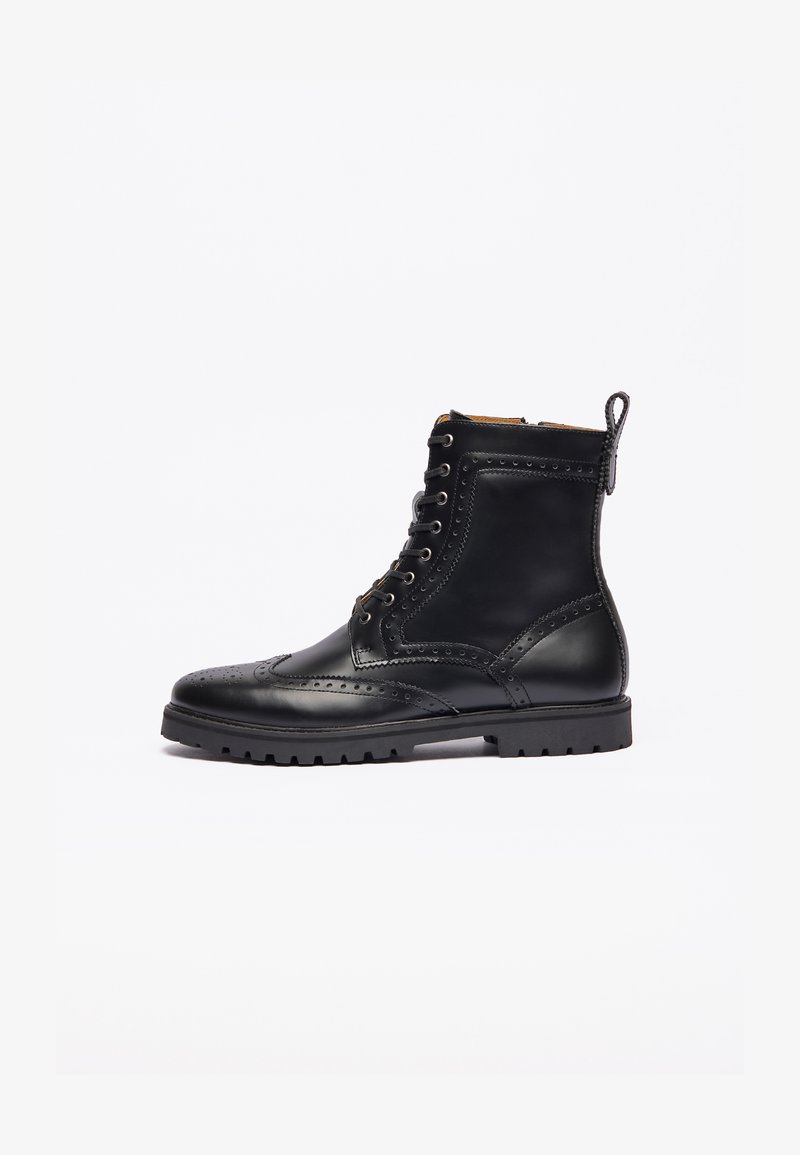 Bottine en cuir noir avec des détails brogue, à lacets à l'avant, tirant à l'arrière, et semelle en caoutchouc épaisse à crampons, présentée en profil latéral.