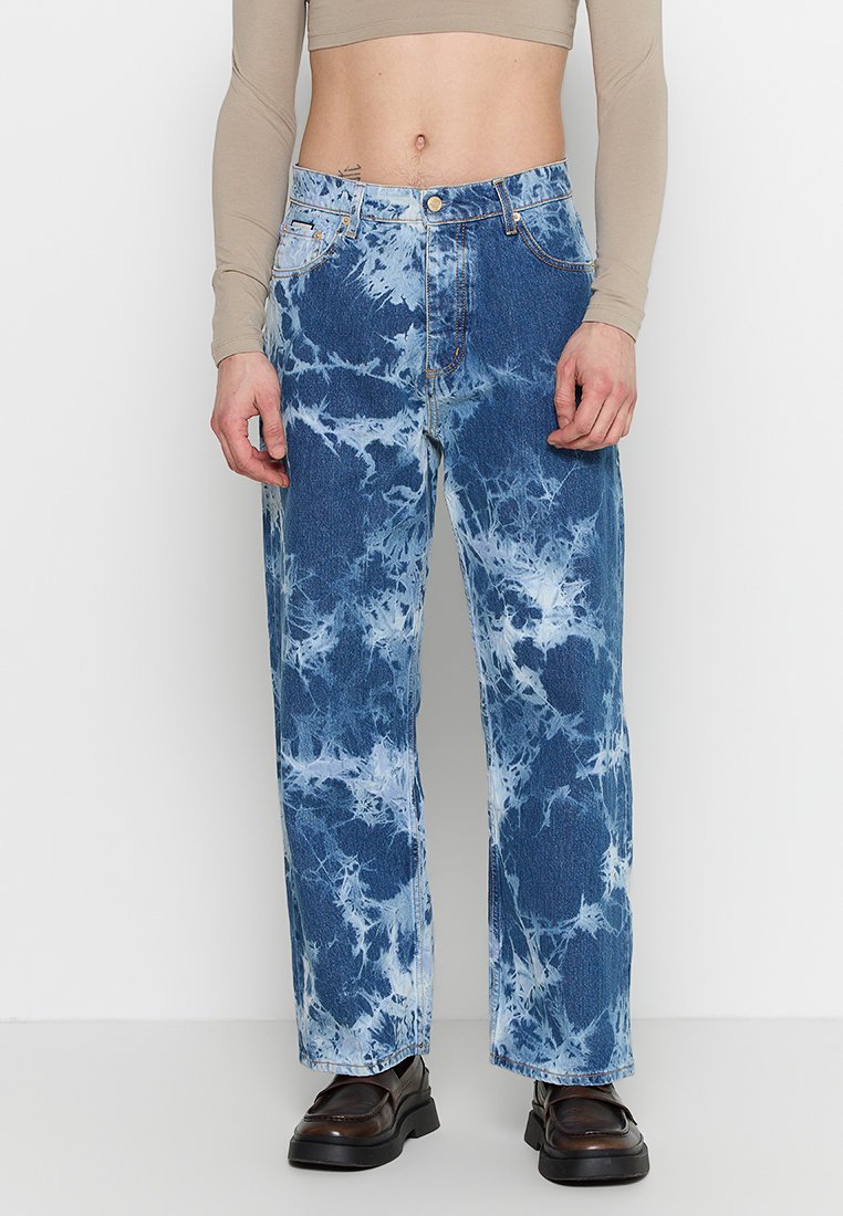 Jeans in denim blu chiaro tie-dye con una vestibilità ampia, dotati di chiusura con bottone e design a cinque tasche. Finitura testurizzata con motivi sbiaditi.
