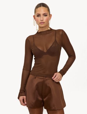 Bruin doorschijnend shirt met lange mouwen en een hoge hals, met daaronder een fijne kanten bralette, gecombineerd met bijpassende bruine satijnen korte broek.