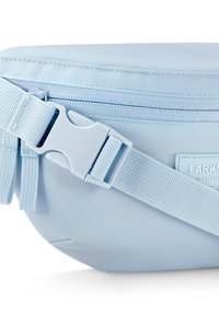 Vaalea sininen suorakulmainen vyölaukku, joka on valmistettu nailonista, ja joka sisältää vetoketjukiinnityksen, säädettävän hihnan ja etupuolella olevan merkkilapun.