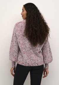 Pulover tricotat de culoare gri cu umbre roz, având un croi lejer, manșete ribbate și o textură moale. Design în stil pulover.