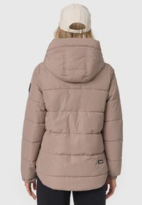 Polstret jakke i blød beige med hætte, der har vandret syninger, elastiske manchetter og et sort logo-patch i nederste venstre hjørne.