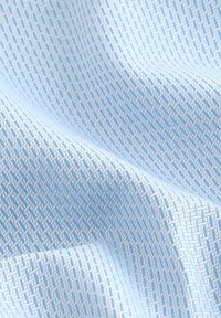 Hellblaues, gemustertes Gewebe mit einem strukturierten, gewebten Design und feinen, subtilen geometrischen Motiven. Weiche und glatte Textur.