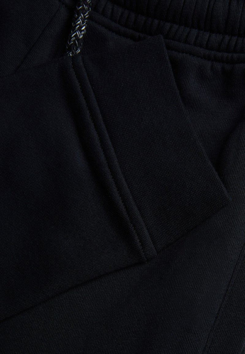 Pantalón De Chándal Con Prácticos Bolsillos Con Cremallera