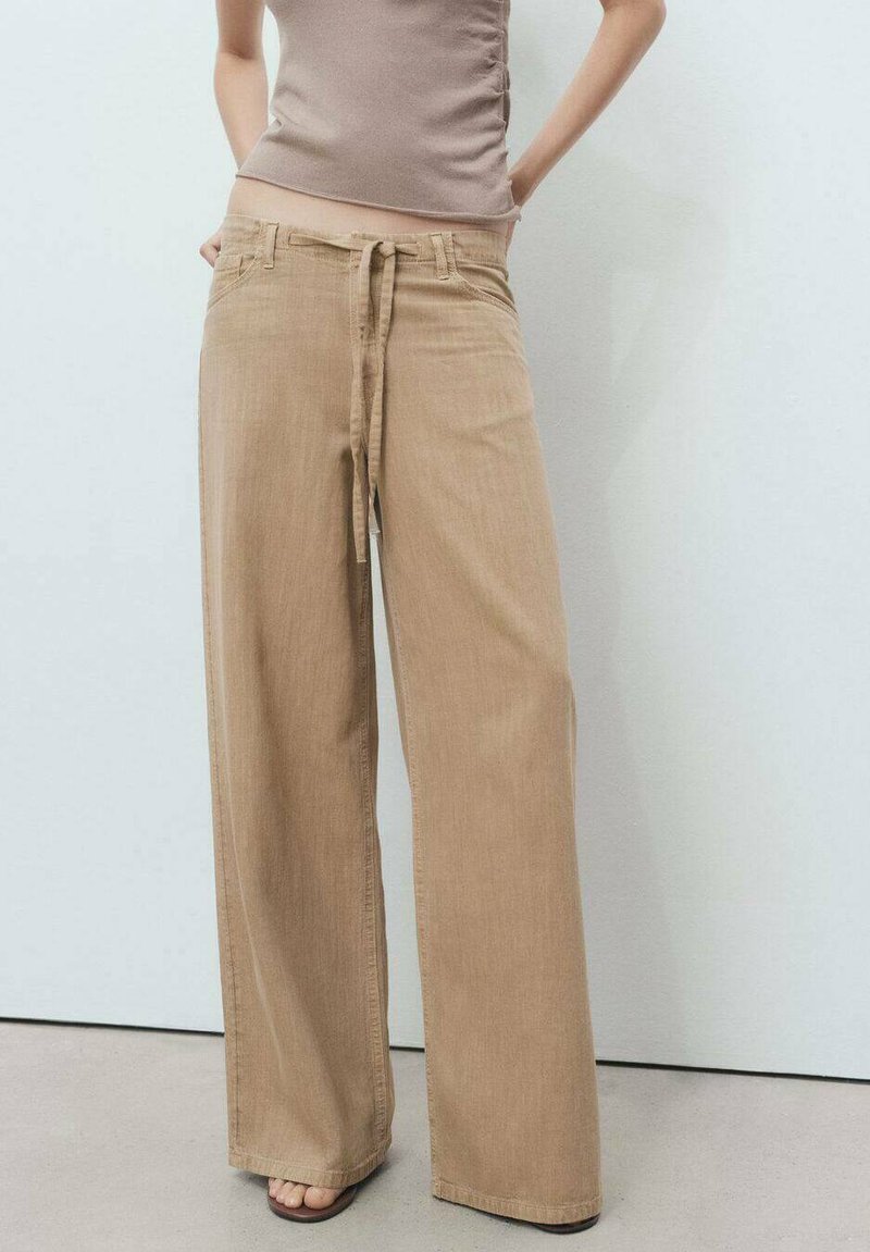 Wide-leg beige trousers with a drawstring waistband, made of soft fabric, featuring a smooth texture and minimalistic design.