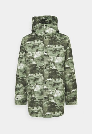 Zöld árnyalatú, kamuflázs mintás dzseki, magas gallérral, kapucnival, patentgombokkal és laza szabással. Vízálló anyagból készült.