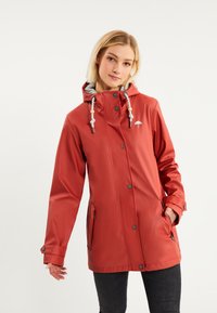 Chaqueta impermeable roja con capucha, forro gris, cordones contrastantes, botones a presión y bolsillos laterales. Textura suave y brillante.