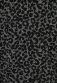 Grau gestrickter Stoff mit gleichmäßig verteiltem schwarzen Leopardenmuster auf der Oberfläche.