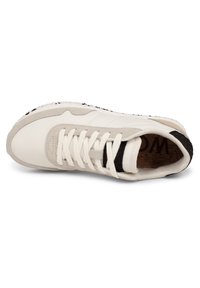 Lace-up sneaker with white leather upper and grey suede accents, black textured heel, and cork insole. Features a minimalistic design.