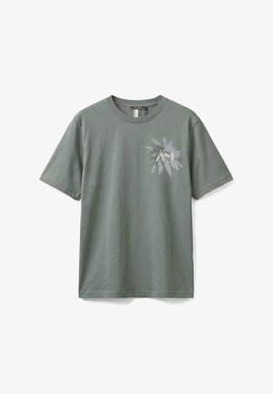 Camiseta de manga corta de color gris verdoso con cuello redondo y pequeño gráfico de palmera en gris claro en la zona del pecho izquierdo.