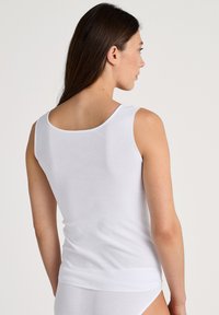 Witte katoenen tanktop met een ronde halslijn en brede schouderbanden. Gladde textuur, aansluitend ontwerp dat tot de taille reikt.