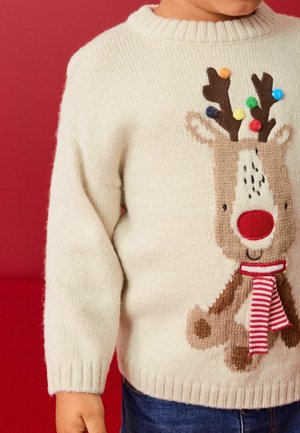 Pull en maille crème avec un motif de renne au nez rouge, des pompons multicolores et une écharpe rayée. Encolure ronde, poignets côtelés.