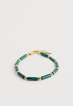 Bracciale con chiusura in oro composto da perle cilindriche alternate di malachite verde e piccole sfere d'oro su sfondo bianco.