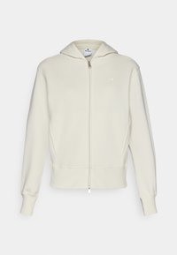 Cream-colored sweatshirt with a zip front, a hood, ribbed cuffs and hem, and a small logo on the left chest. Smooth cotton-blend fabric.