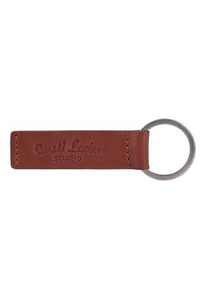 Brauner Leder-Schlüsselanhänger mit Metallring und dem eingeprägten Text "Gusti Leder studio" auf dem Lederband.