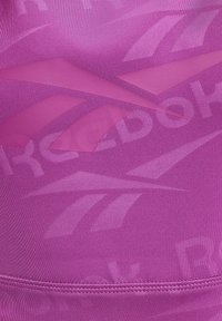 Ružový športový tielko s textúrovaným dizajnom, ktoré obsahuje geometrické vzory a jemné logo. Materiál je hladký a pružný.