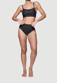 Schwarzes Dessous-Set mit einem kurzen Top mit dünnen Trägern und hochgeschnittenen Slips, gefertigt aus glattem, dehnbarem Stoff mit Logo-Akzenten.