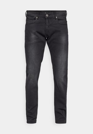 Fekete farmernadrág, karcsú szabással, öt zsebbel és gombos rögzítéssel. Finom kopás és sima textúra jellemzi.