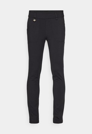 Black stretchy pants with a slim fit, featuring two front pockets and a decorative hardware accent near the waistband. Smooth texture.