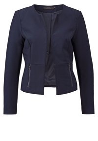 Blazer bleu marine en tissu lisse, col rond et manches longues. Comprend deux poches latérales zippées et un design épuré et structuré.